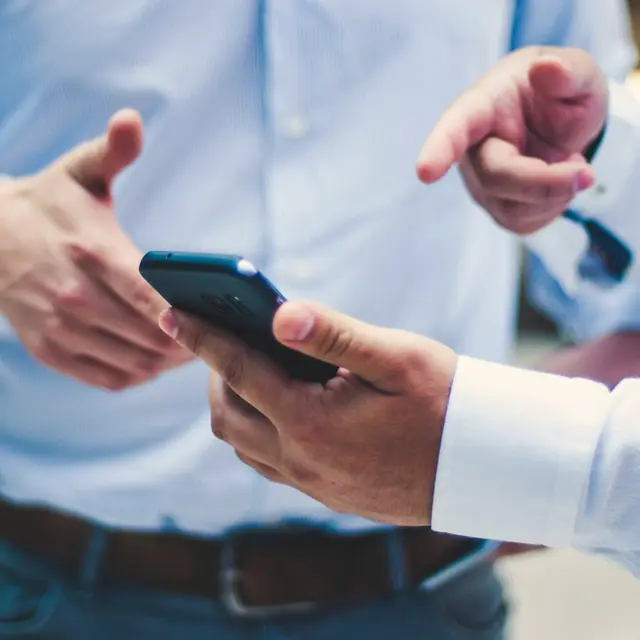 Un asesor enseña el teléfono a un cliente