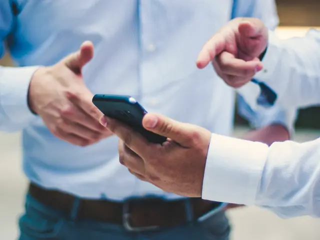 Un asesor enseña el teléfono a un cliente